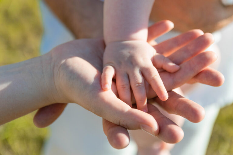 canva close up photo of babys hand on parents hands MAETteT 31c 768x512